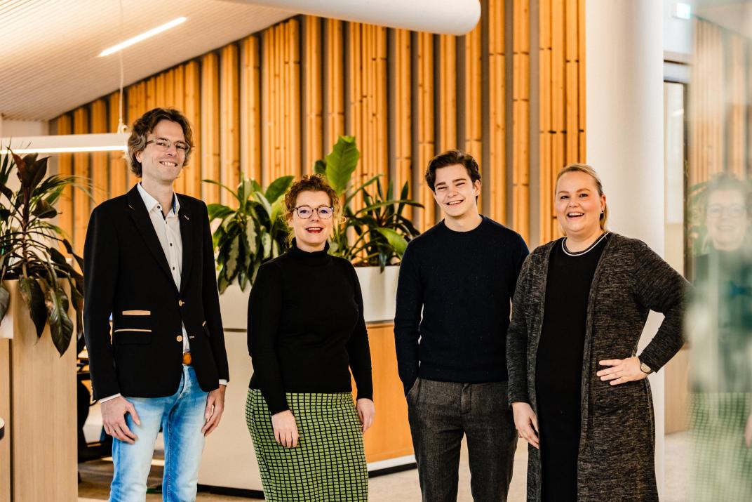 Vier collega's lachend op een rij