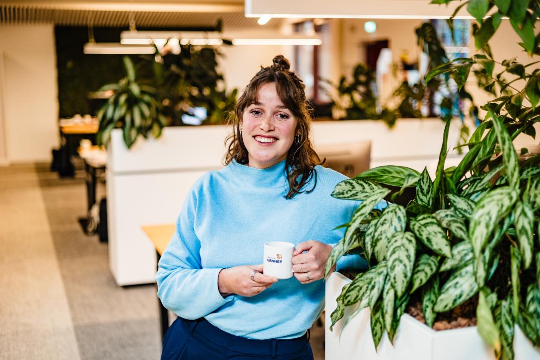Medewerker met koffiemok in de hand