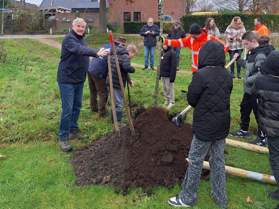 Wethouder en kinderen planten boom