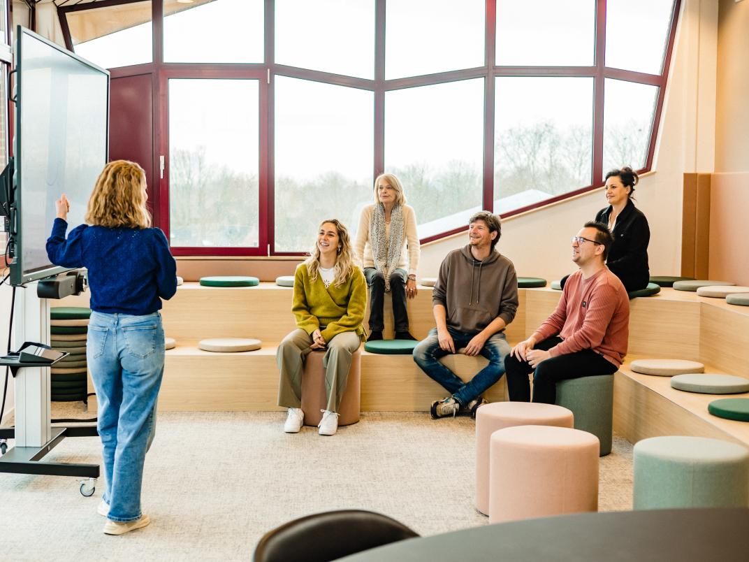 Groep medewerkers volgt presentatie