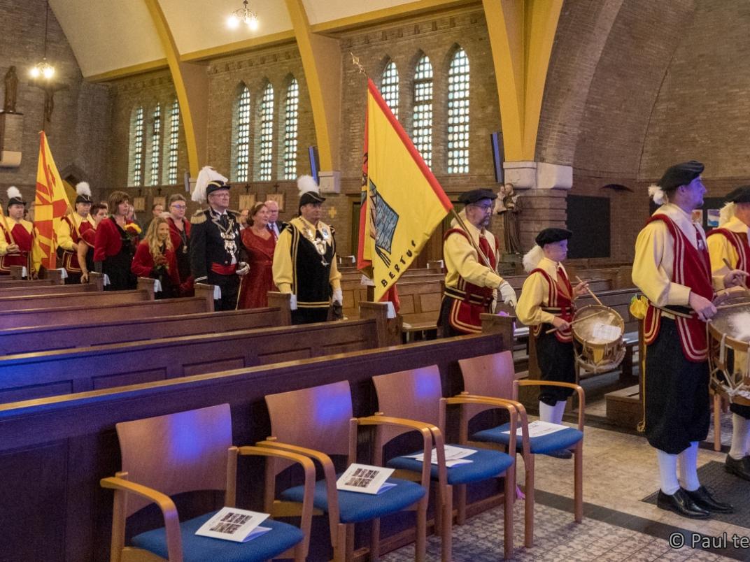 Muziek en vaandels komen de kerk binnen